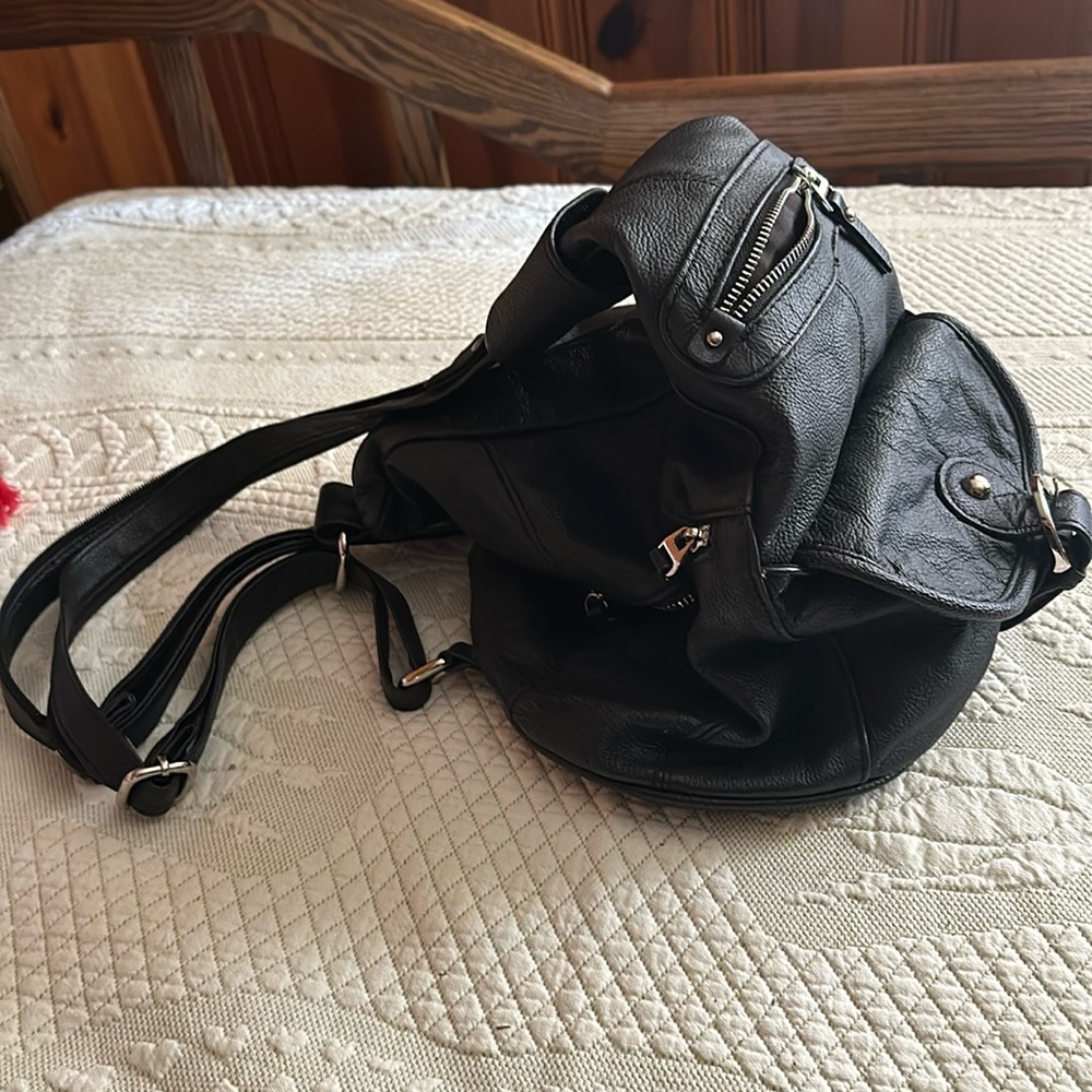 Black pocketbook/backpack made out of man-made materials and silver hardware